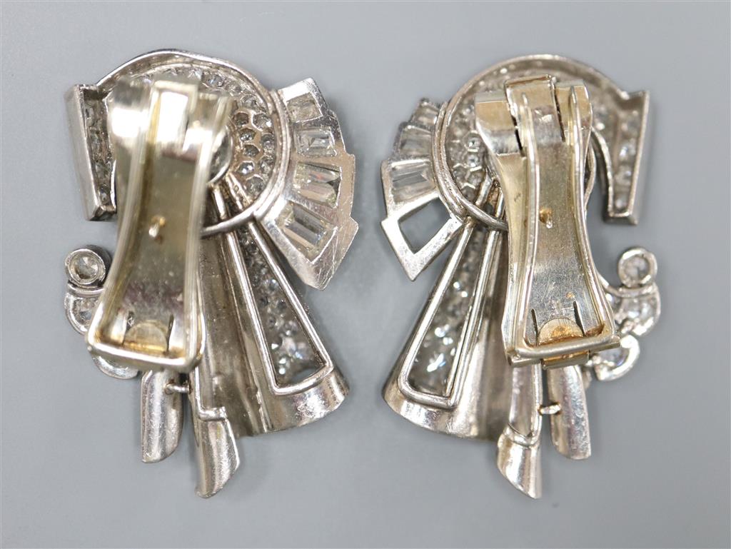 A pair of diamond and synthetic? sapphire clips in white metal settings (tests as platinum), white metal fitments